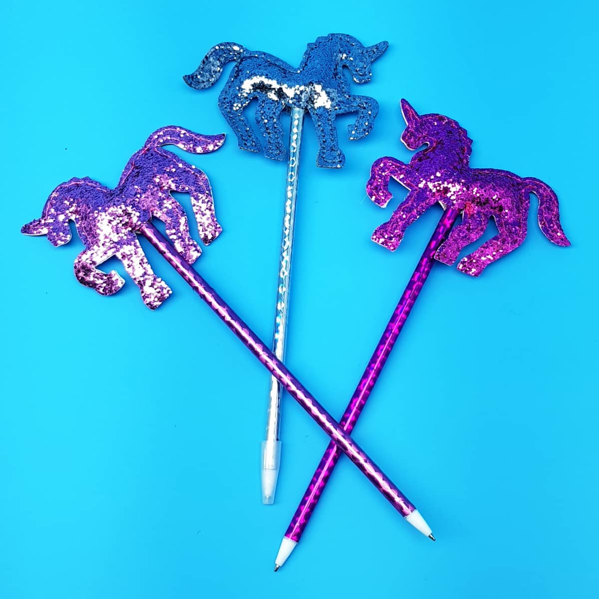 Stifte mit glitzernden Einhorn-Spitzen und blauer Schriftfarbe